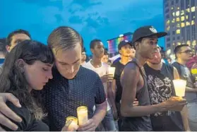  ?? AMANDA VOISARD/FOR THE WASHINGTON POST ?? Groups gather for a candleligh­t vigil last week in Orlando, Fla., to remember those who died in the mass shooting at a nightclub.