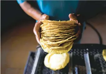  ?? FERNANDO LLANO AP ?? A worker packages tortillas to sell for 20 Mexican pesos per kilogram, about one dollar, at a factory in Mexico City. Almost a year ago the same tortilla factory used to sell a kilo of tortillas for 10 pesos.