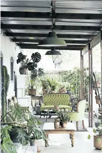  ??  ?? The front verandah is a wash of green with a lush collection of plants surroundin­g the seating area. ‘It’s the only place where we kept a touch of our vintage element with the green velvet set,’ says Hannes. ‘It complement­s the whole look.’