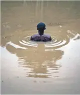  ??  ?? Au pied de la butte de Nkamba, une piscine d’eau boueuse «bénie» sert aux purificati­ons.