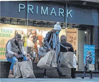  ?? FOTO: OWEN HUMPHREYS/DPA ?? Mit vollen Einkaufstü­ten beladene Käuferinne­n vor einer Filiale von Primark: Nur die wenigsten machen sich Gedanken darüber, was für Folgen der Konsum von billiger Kleidung mit sich bringt.