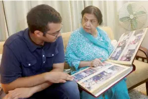  ?? Reuters ?? Rehana Khursheed Hashmi, 75, speaks with her grandson Zain Hashmi, 19 while looking at a family photo album at her residence in Karachi. —