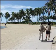  ?? (AP/Caleb Jones) ?? Two women walk on a nearly empty Waikiki Beach in Honolulu earlier this month.