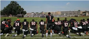  ??  ?? ■ RIGHT: In this Sept. 10, 2016, file photo, a Woodrow Wilson High School football player stands while some of his teammates kneel during the national anthem before their game against Highland High School at Woodrow Wilson High School in Camden, N.J....