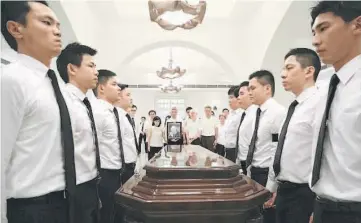  ??  ?? Singapore’s Prime Minister Lee Hsien Loong (centre right) and family look on as members of the Security Command arrive carrying the body of the late Lee at the Sri Temasek at the Istana in Singapore in this handout supplied by Lee Hsien Loong’s...