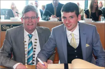  ??  ?? Champion jockey Derek Fox signing the distinguis­hed visitors book with Cathaoirle­ach Cllr Hubert Keaney