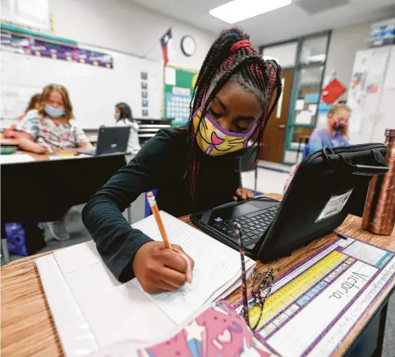  ?? Jason Fochtman / Staff photograph­er ?? Fifth-grader Victoria Thomas uses her laptop to work on math Sept. 8, 2020, at William Lloyd Meador Elementary School in Willis.