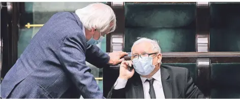  ?? FOTO: IMAGO IMAGES ?? Strippenzi­ehen geht auch mit Maske: Jaroslaw Kaczynski (r.), PiS-Parteichef und graue Eminenz der Regierung, Mitte April im Parlament.