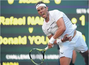  ??  ?? Rafael Nadal launches a big serve during his victory over Donald Young.