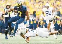  ?? AP ?? Michigan ball carrier Donovan Edwards, left, leaps to avoid a tackle bid from Penn State’s Jaylen Reed at Michigan Stadium on Saturday in Ann Arbor, Michigan.