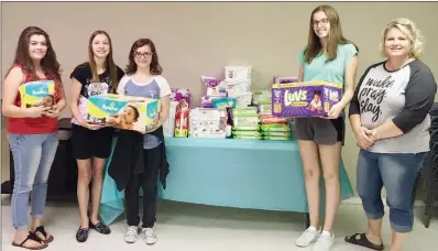  ?? COURTESY OF SHELLI JOHNSON ?? A diaper donation drive was one of the first projects undertaken by the new Better Together 4-H Club. Shown with a portion of the donations are club members, from left, Jenny Serrette, Abbi Johnson, Kelsey Davis and Claire Fine; and Joseph’s House of...