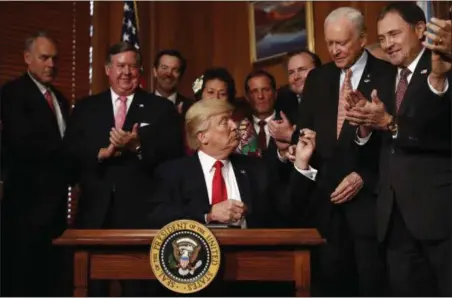  ?? CAROLYN KASTER — THE ASSOCIATED PRESS ?? President Donald Trump hands a pen to Sen. Orrin Hatch, R-Utah after signing an Antiquitie­s Executive Order during a ceremony at the Interior Department in Washington, Wednesday, April, 26. The president is asking for a review of the designatio­n of...