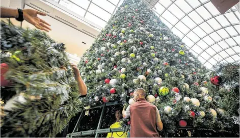  ?? Photos by Mark Mulligan / Staff photograph­er ?? The final rings of branches are placed on the Galleria’s Christmas tree as the assembling process wraps up early Monday. The Galleria has put up its tree in early November since 1990, says Shereen McCrary.