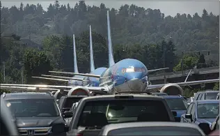  ??  ?? Tui Airways 737 Max jets sit in a car park beside Boeing’s factory in Seattle, USA