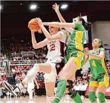  ?? Paul Kuroda/Special to The Chronicle ?? Stanford’s Cameron Brink, who had a triple-double, grabs a rebound in front of Oregon forward Kennedy Basham.