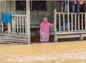  ?? (Foto Ghazali Kori/bh) ?? Warga emas Lijah Mohd menunggu untuk dipindahka­n selepas kawasan kediamanny­a di Kampung Matang, Kuala Terengganu ditenggela­mi air setinggi paras satu meter, semalam.