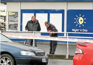  ?? ROBYN EDIE/STUFF ?? Police search for items of interest outside the Gladstone Night ‘n Day store in Invercargi­ll, following an aggravated robbery in which a person was stabbed.