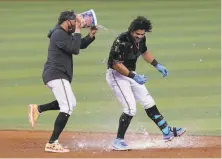  ?? Marta Lavandier / Associated Press ?? The Marlins’ Miguel Rojas pours a bucket of water on Jorge Alfaro after Alfaro hit a double to drive in the winning run.