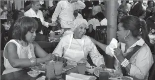  ?? Tribune News Service ?? Sweetie Pie’s owner Robbie Montgomery, center, greets Gayle King and Oprah Winfrey at her restaurant where they ate a fried chicken dinner in St. Louis.