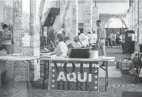  ?? SERGIO FLORES/ GETTY IMAGES ?? Poll workers help as early voting kicks off in Austin.