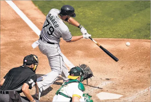  ?? ERIC RISBERG/AP ?? Chicago White Sox's Jose Abreu, top, hits a two-run home run in front of Oakland Athletics catcher Sean Murphy, bottom right, during Tuesday's game in Oakland, Calif.