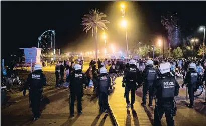  ?? JOSEP LAGO / AFP ?? La Guàrdia urbana escombrant la platja de Sant Miquel a la Barcelonet­a dissabte a la nit