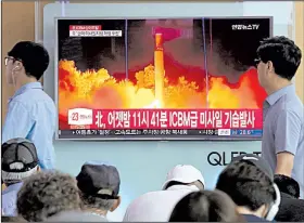  ?? AP/AHN YOUNG-JOON ?? People at a railway station in Seoul, South Korea, watch Saturday as a television news report shows North Korea’s latest test launch of an interconti­nental ballistic missile.