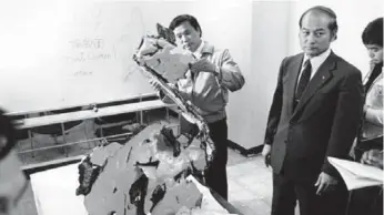  ?? MIKAMI/THE ASSOCIATED PRESS FILE PHOTO ?? Experts examine a piece of Korean Air Lines Flight 007, which was shot down by a Soviet fighter jet in 1983.