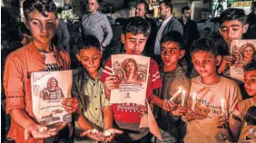  ?? MAHMUD HAMS
AFP VIA GETTY IMAGES ?? Children take part in a vigil for Shireen Abu Akleh, below, Wednesday in Gaza City.