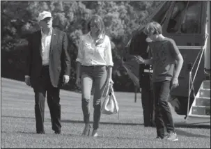  ?? The Associated Press ?? SOUTH LAWN:
President Donald Trump, first lady Melania Trump, and their son Barron Trump walk on the South Lawn upon arrival Sunday at the White House in Washington from Camp David in Maryland.