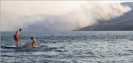  ?? RON SEYMOUR/The Daily Courier ?? Life goes on in the Central Okanagan despite wildfires burning in Okanagan Mountain Provincial Park and elsewhere in the region, as this view from Beach Avenue in Peachland shows.