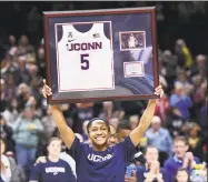  ?? Stephen Dunn / Associated Press ?? UConn’s Crystal Dangerfiel­d holds up her framed jersey during senior day ceremonies in February.