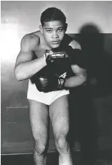  ?? AP ?? LEFT: Heavyweigh­t boxer Joe Louis in 1935. RIGHT: The gloves Louis used in a famous bout against German fighter Max Schmeling in 1936.