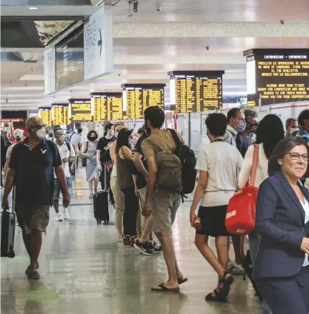  ?? LAPRESSE/ANSA ?? A terra
Passeggeri a Roma Termini, a fianco De Micheli e “la campanella” di Renzi e Letta