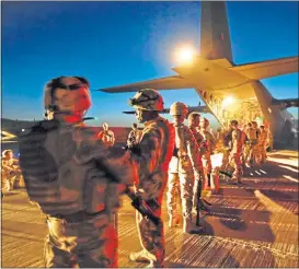  ??  ?? Black Watch troops board a plane in Afghanista­n and, main, their famous red hackle
