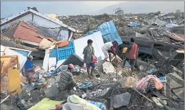  ?? DITA ALANGKARA — THE ASSOCIATED PRESS ?? A family scavenges for salvageabl­e items Friday from the ruins of their house in Petobo, which was wiped out by a massive earthquake in Palu, Central Sulawesi, Indonesia.