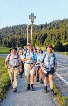  ?? Fotos: Maier ?? Sie folgen dem Kreuz: Das Kruzifix darf auf der Fußwallfah­rt nach Flüeli natürlich nicht fehlen.