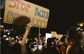  ?? Lola Gomez / Austin American-Statesman 2020 ?? Demonstrat­ors protest the death of George Floyd and police brutality against Black people in front of the Austin Police Department headquarte­rs on June 5, 2020, in the Texas state capital.