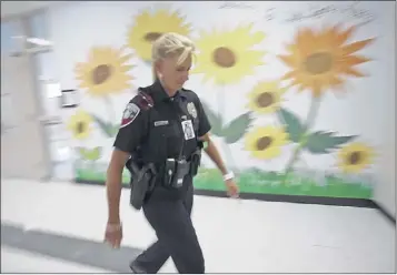  ?? WILFREDO LEE/ASSOCIATED PRESS ?? Dara Van Antwerp, the school resource officer at Panther Run Elementary School in Pembroke Pines, Fla., walks the hallways of the school where she teaches a Gang Resistance And Drug Education (GRADE) program in the Fort Lauderdale suburb.