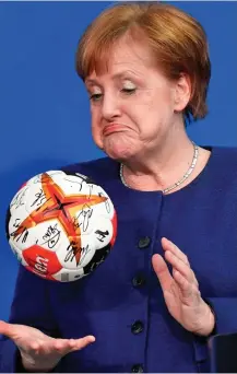  ??  ?? Extra time? Mrs Merkel plays with a handball from the German team yesterday. Today she meets Mrs May