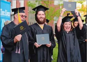  ?? SARAH GORDON/THE DAY ?? Hunter Rickards, center, laughs as he poses for a photo with his parents, and fellow graduates, Susan and Jim, during Three Rivers Community College’s commenceme­nt ceremony on Wednesday at the school in Norwich. The three family members graduated...