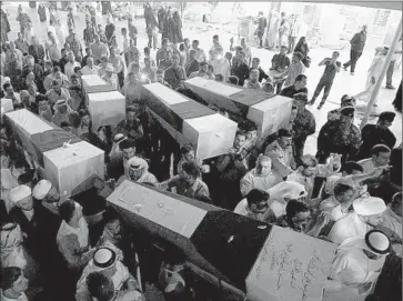  ?? Jaber al- Helo
Associated Press ?? COFFINS, draped with Kuwait’s f lag and bearing victims of Friday’s suicide blast in the emirate, arrive in the Shiite holy city of Najaf in neighborin­g Iraq. Shiite Muslims from around the globe seek to be buried in Najaf.