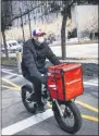  ?? JOHN MINCHILLO ?? FILE - In this March 16, 2020 file photo, a delivery worker rides his bicycle along a path on the West Side Highway in New York. The pandemic shuffled the deck for the so-called gig economy as fear of contractin­g the coronaviru­s led many who once traveled in shared vehicles to stay home, and grocery delivery services struggled to keep up with demand from people who didn’t want to risk stepping into a store. rather cook his own food than order in, and he prefers to pick his own produce at the store.
“I did a lot of my appointmen­ts in restaurant­s, and it was a treat, to go out and