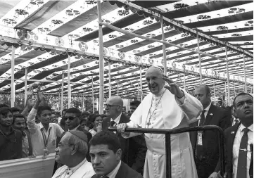  ??  ?? Pope Francis waves to the crowd as he arrives for a meeting with young people at Notre Dame College in Dhaka. — AFP photo