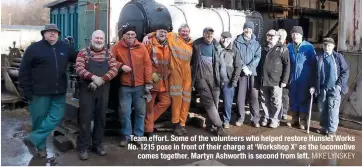  ?? MIKE LYNSKEY ?? Team effort. Some of the volunteers who helped restore Hunslet Works No. 1215 pose in front of their charge at ‘Workshop X’ as the locomotive comes together. Martyn Ashworth is second from left.