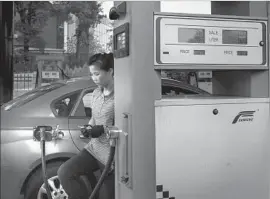  ?? Ed Jones AFP/Getty Images ?? AN ATTENDANT fills a taxi up with gas in Pyongyang, the capital of North Korea, which is entirely dependent on imported fuel oil, most of it from China.