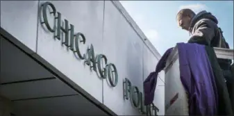  ?? ANNIE COSTABILE — CHICAGO SUN-TIMES VIA AP ?? Photo from video of a worker hanging purple and black bunting outside Chicago Police District 2 Wentworth headquarte­rs in Chicago, Tuesday in memory of slain Chicago Police Officer Samuel Jimenez. Jimenez was killed during Monday’s shooting at Mercy Hospital in Chicago.