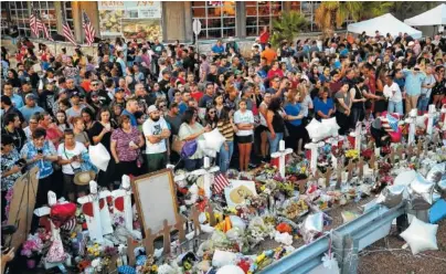  ?? AP PHOTO/JOHN LOCHER ?? People crowd around a makeshift memorial at the scene of a mass shooting at a shopping complex in El Paso, Texas, in August.