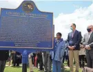  ??  ?? From right, Maryland Gov. Larry Hogan, Baltimore County Executive John Olszewski and Maryland House Speaker Adrienne Jones look at a historic marker in Towson that memorializ­es Howard Cooper, a 15-year-old dragged from a jailhouse and hanged from a tree by a mob of white men in 1885. BRIAN WITTE/AP