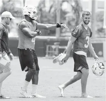  ?? LYNNE SLADKY/AP ?? Dolphins linebacker Nate Orchard, left, walks off the field with quarterbac­k Josh Rosen, right, after practice at the team's training facility earlier this summer. Rosen is one of several new additions to the team with limited risk tied to them.